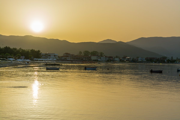 A picture taken from the sea showing the beach and the settlement of Stavros during the sunset.