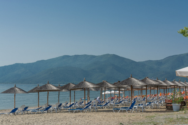 Many umbrellas and sunbeds lined up on the beach of Vrasna in the area of Volvi, Thessaloniki.