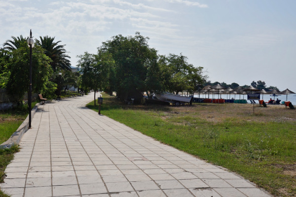 A paved path at the Yerakini coastal promenade close by the sandy beach.